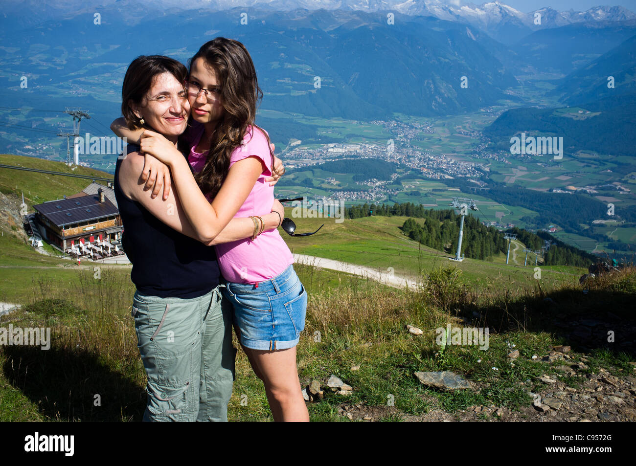 Mother and daughter hugging on top of Kronplatz Mountain in the Italian Dolomites. Stock Photo