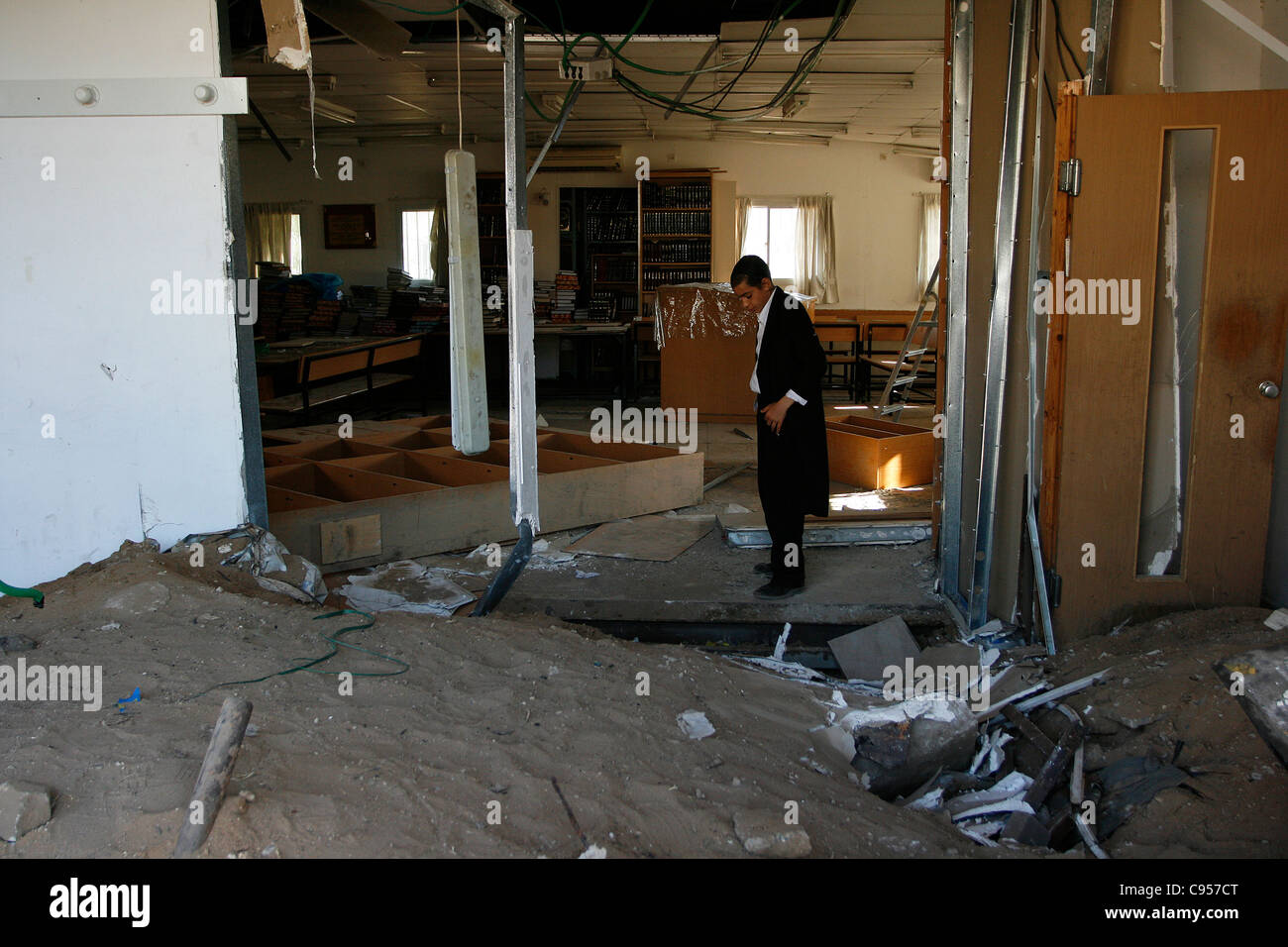 A Jewish boy is observing the destruction of the furnishings of the local synagogue after a grad rocket attack in Ashdod, Israel Stock Photo