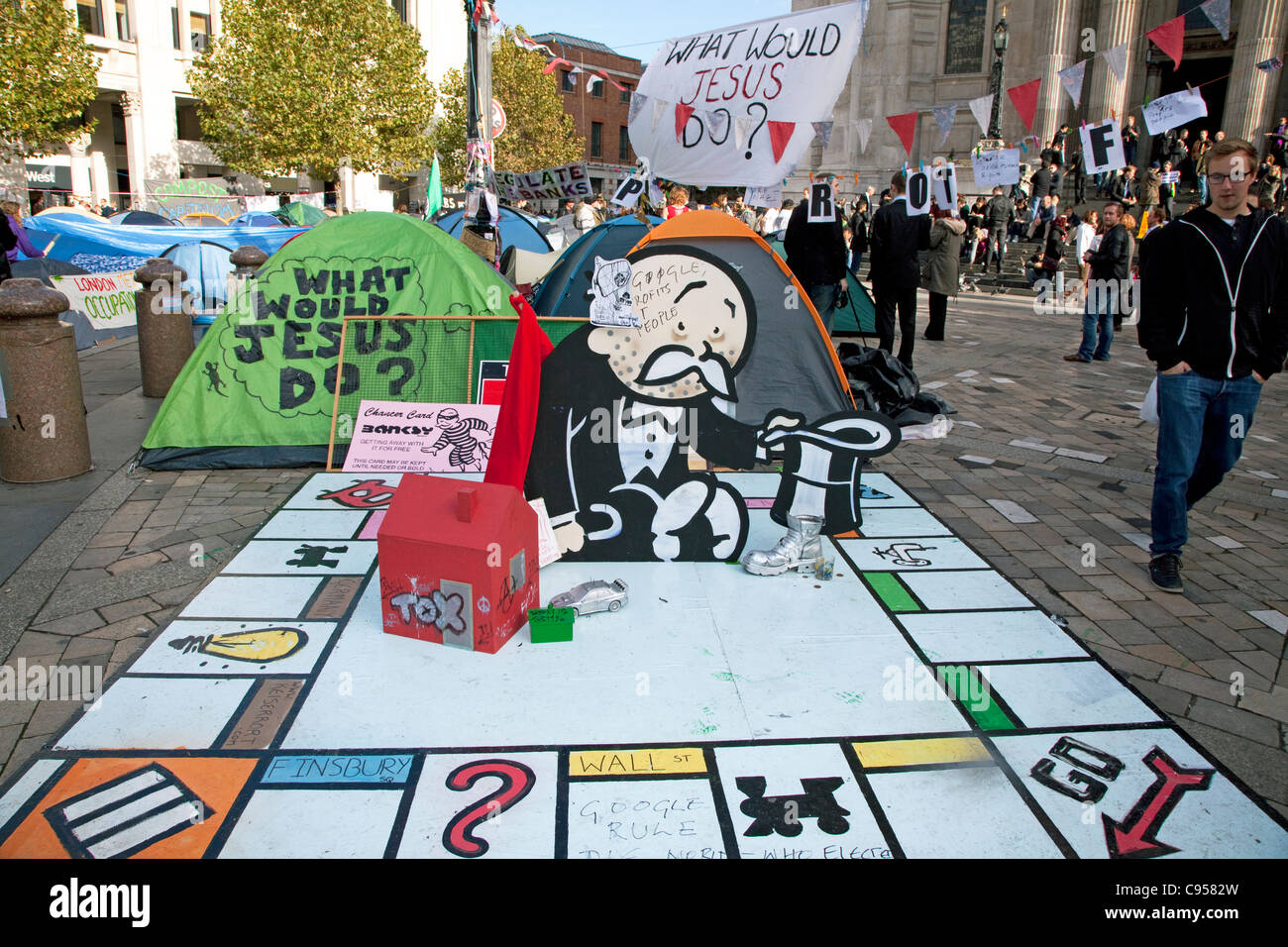 Occupy London anti-capitalism protest camp outside St Paul's Cathedral, London with Monopoly board installation by Banksy Stock Photo