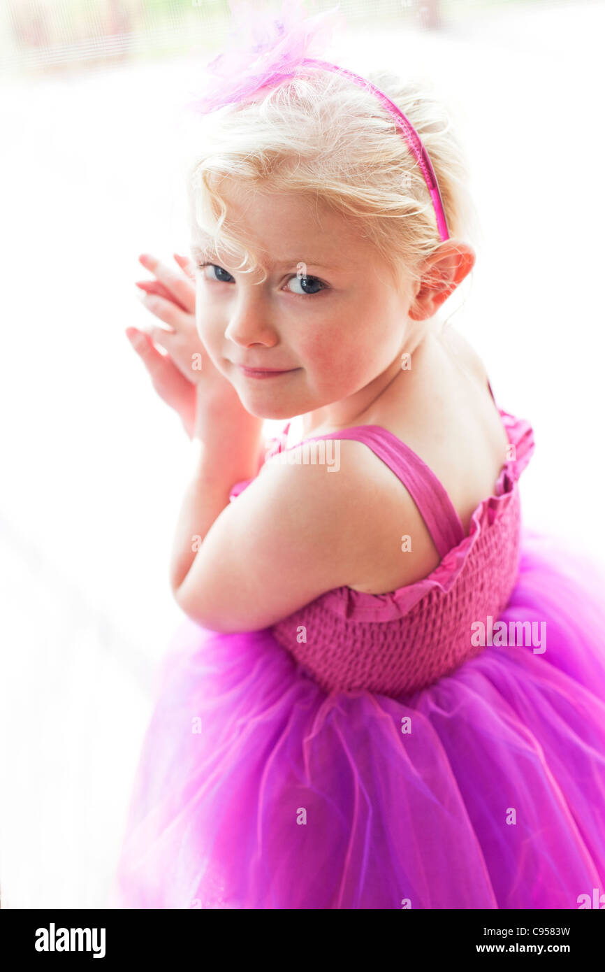Portrait of happy girl 4-6 yrs old wearing pink dress. Stock Photo