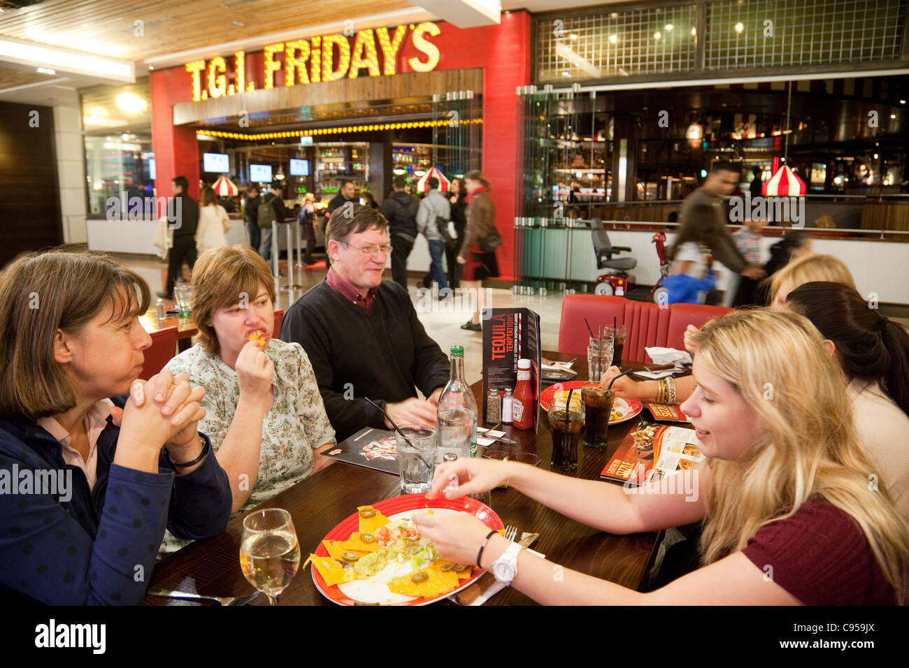 A family eating at TGI Fridays restaurant, Westfield shopping mall centre, Stratford, London UK Stock Photo