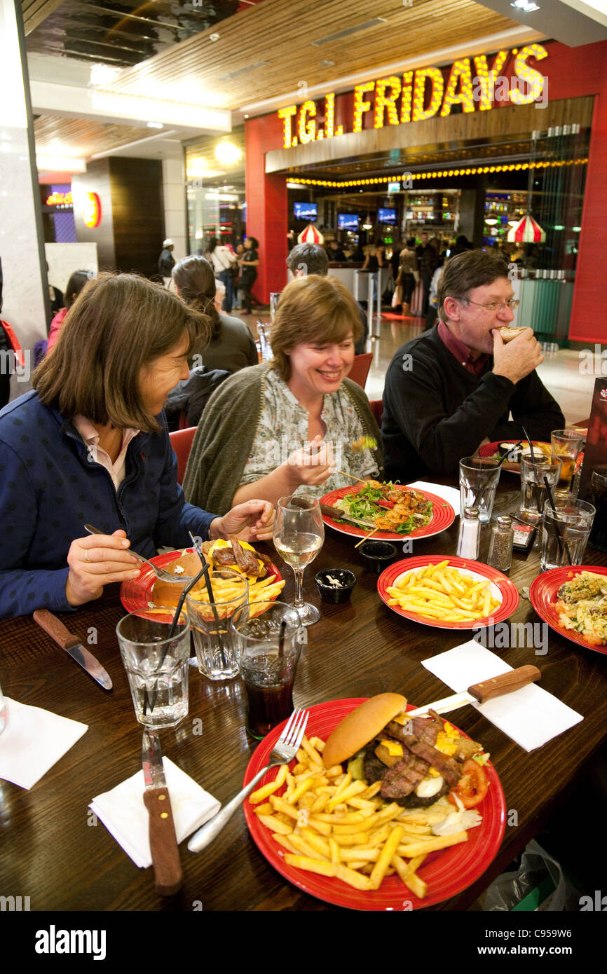 People eating at TGI Fridays restaurant, Westfield shopping mall centre, Stratford, London UK Stock Photo