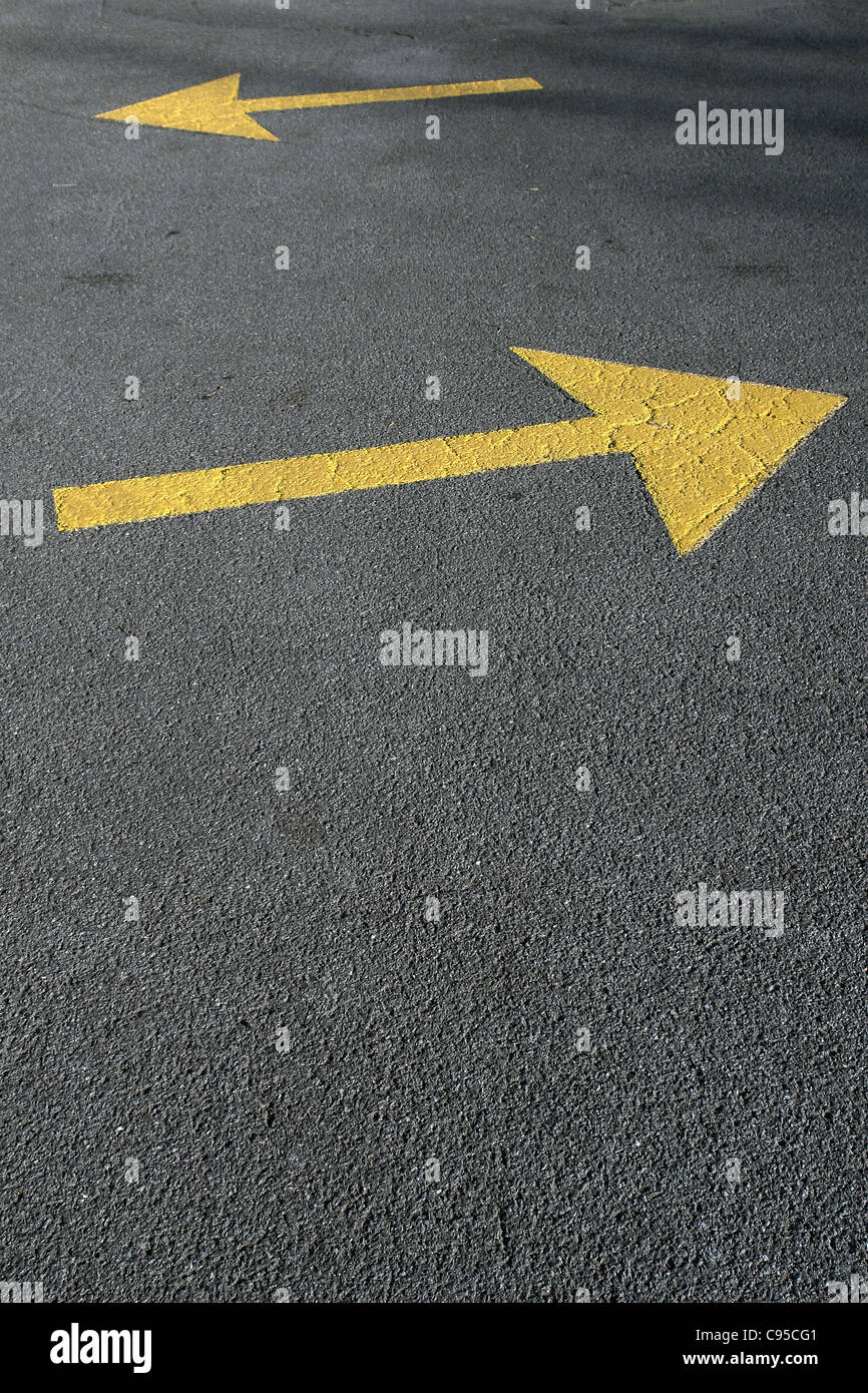 Photograph of Two Yellow Directional Arrows on Road Pavement Copy Space Stock Photo