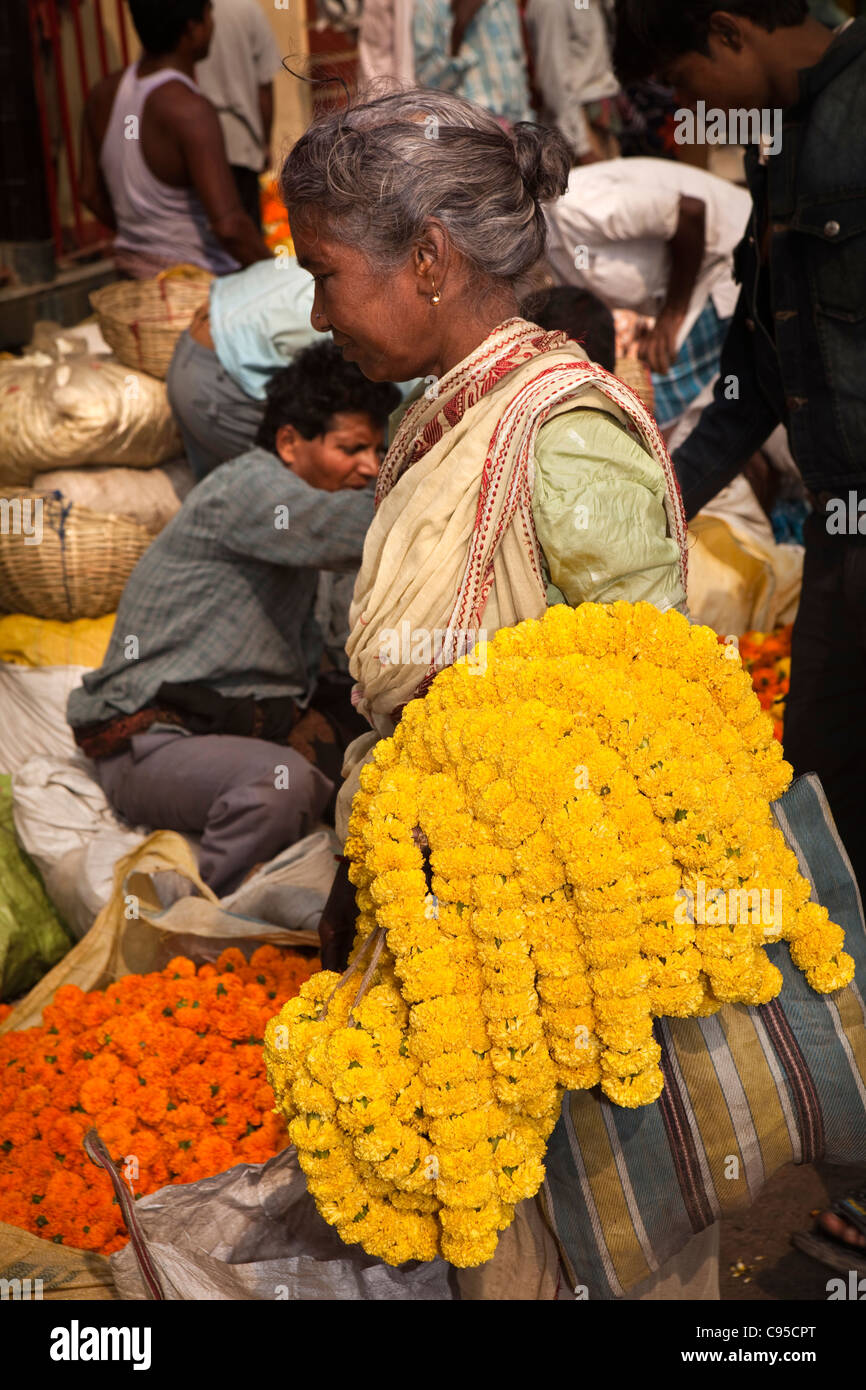 India, West Bengal, Kolkata, Mullik Ghat, flower market, woman with strings of marigold garlands on her arm Stock Photo