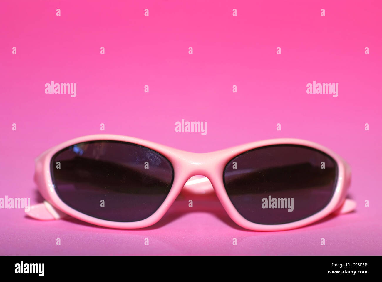Pair of pink women's sports sunglasses on a pink background Stock Photo
