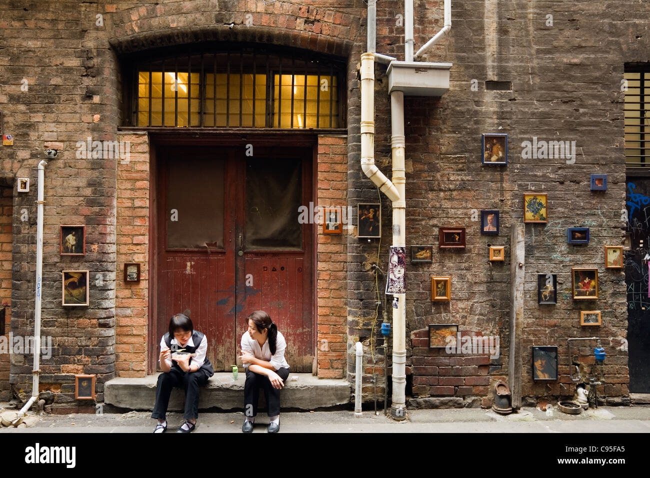 Workers have a break in one of Melbourne's laneways, lined with street art. Melbourne, Victoria, Australia Stock Photo