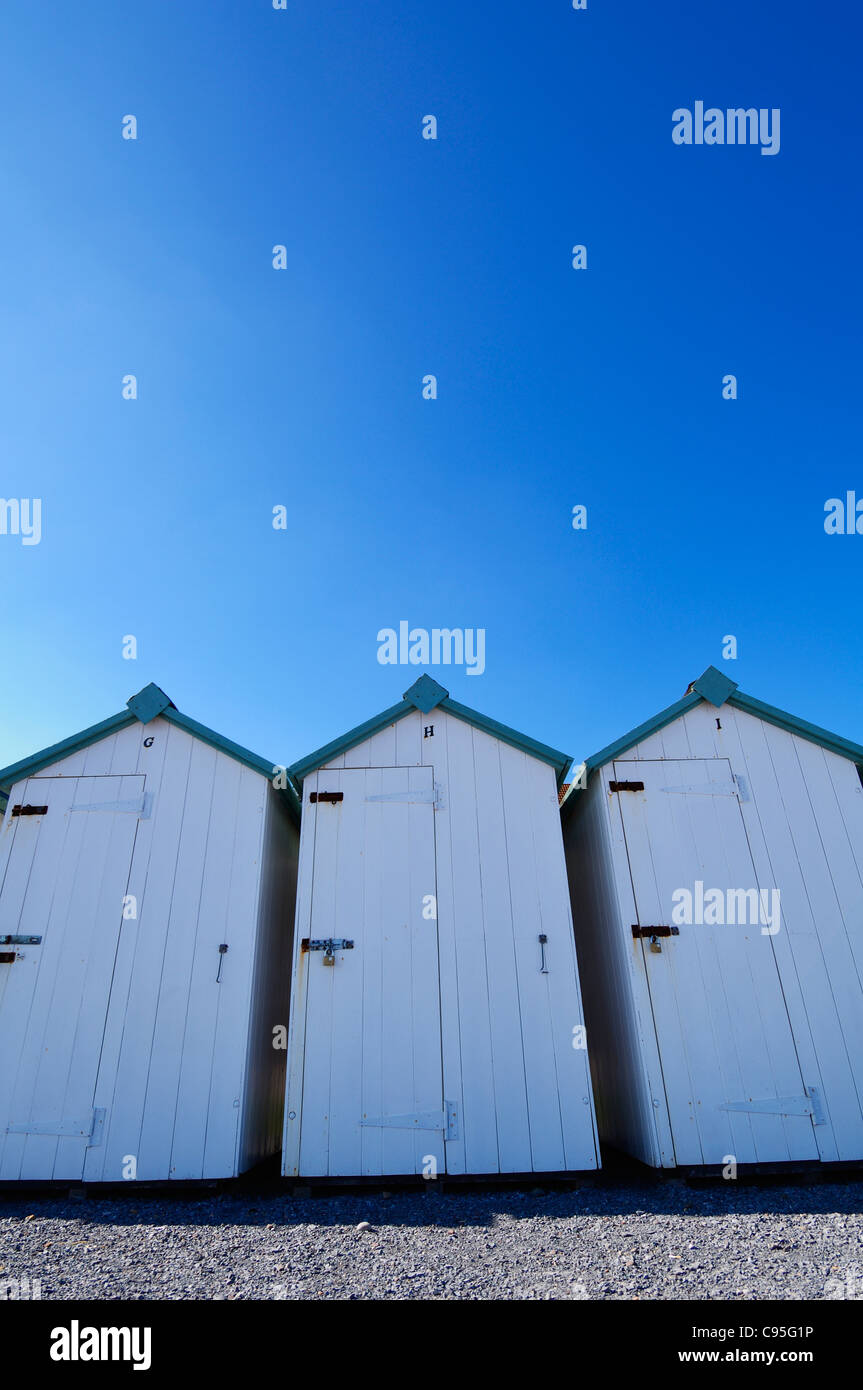 White beach huts under a clear blue sky at Budleigh Salterton, Devon, England. Stock Photo