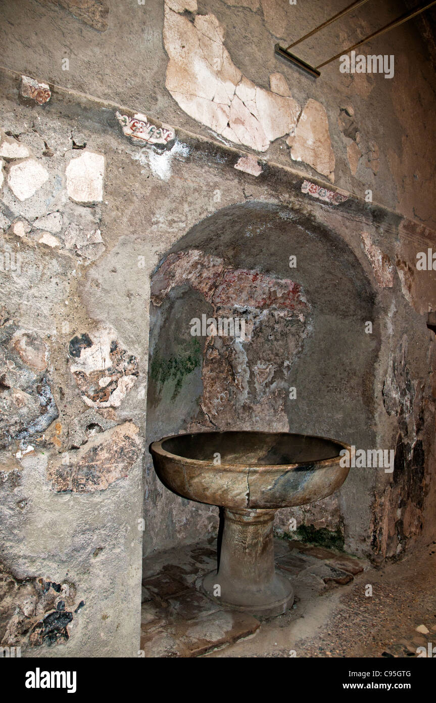 A marble washing bowl on a pedestal situated in an arched apse in the men's changing room of the central baths, Herculaneum Stock Photo