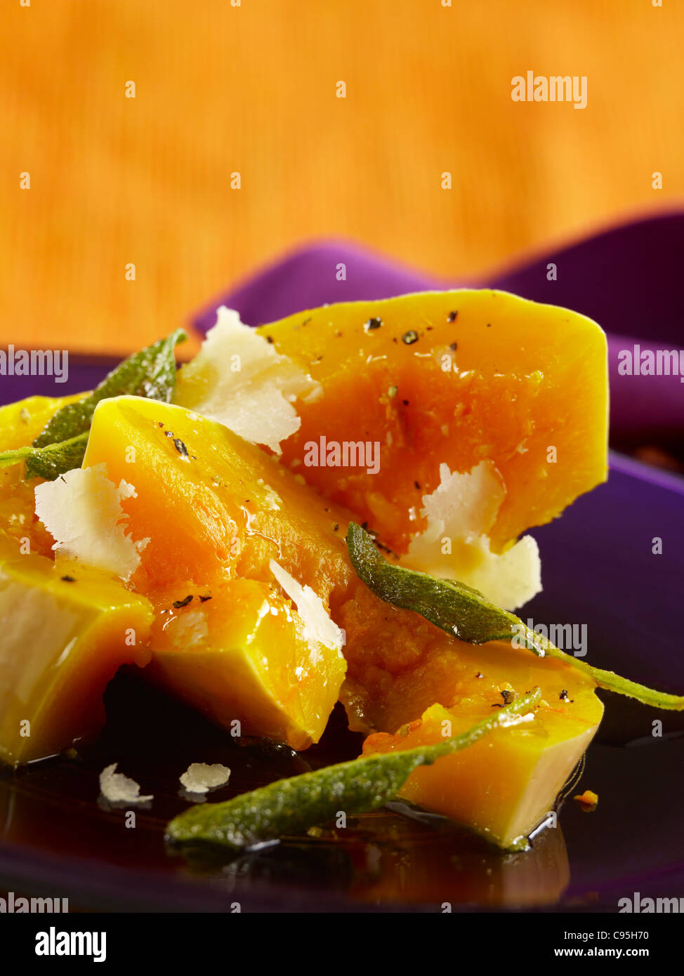 Butternut squash with sage leaves topped with shaved Parmesan Stock Photo