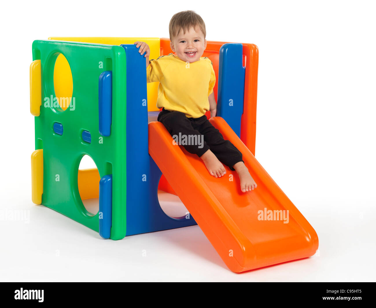 Happy one and a half year old child on a slide. Isolated on white background. Stock Photo