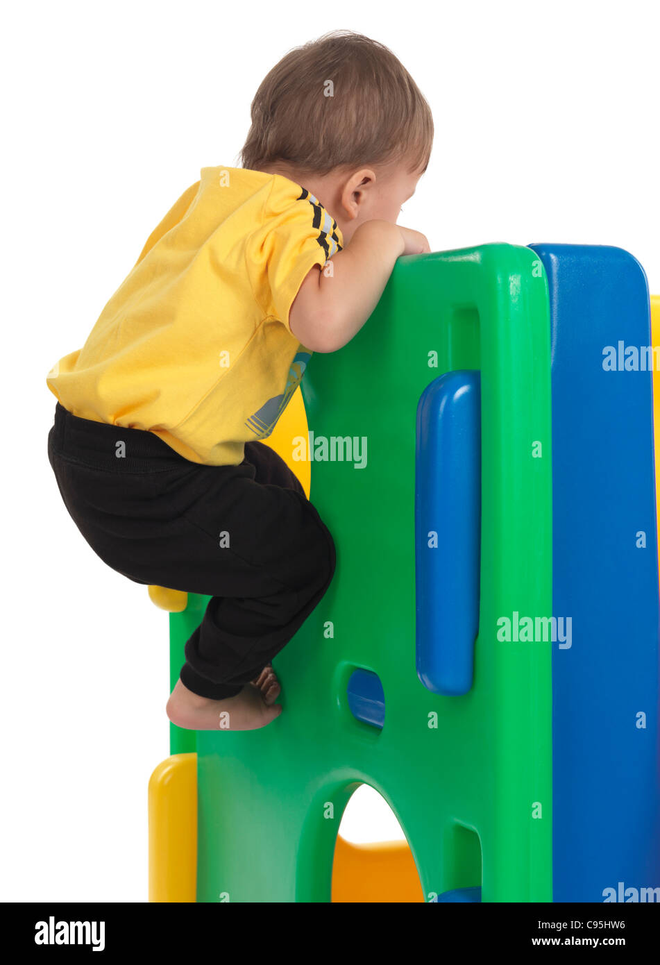 Happy one and a half year old child climbing a slide. Isolated on white background. Stock Photo