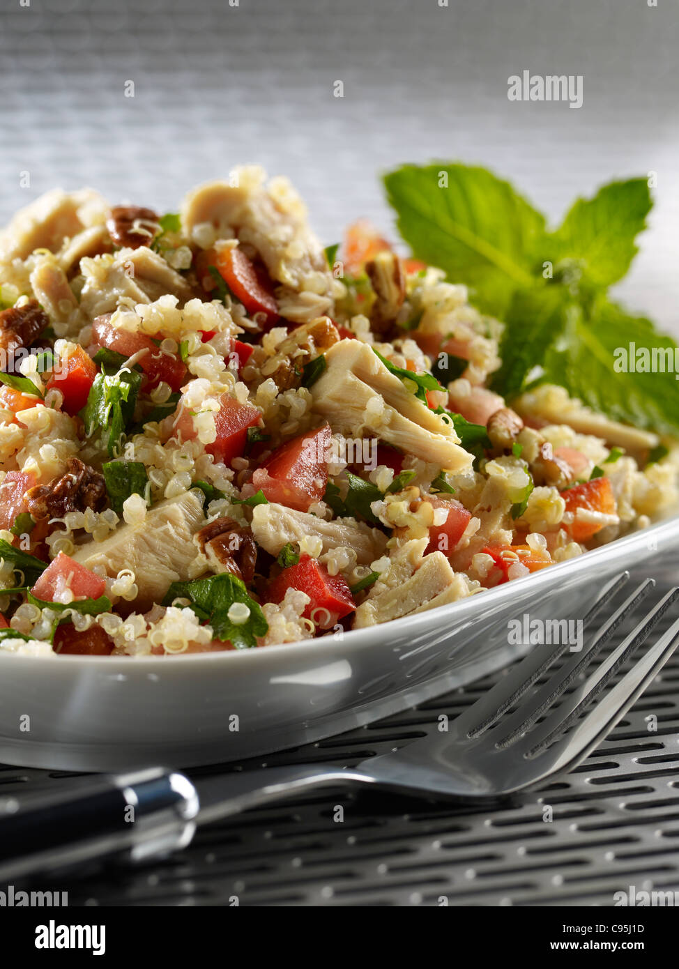 Tuna quinoa salad with tomato, onion, greens and nuts Stock Photo