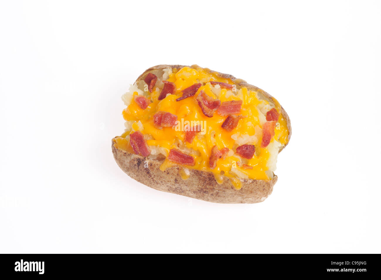 Baked potato topped with orange cheese and bacon bits on white background cutout. Stock Photo