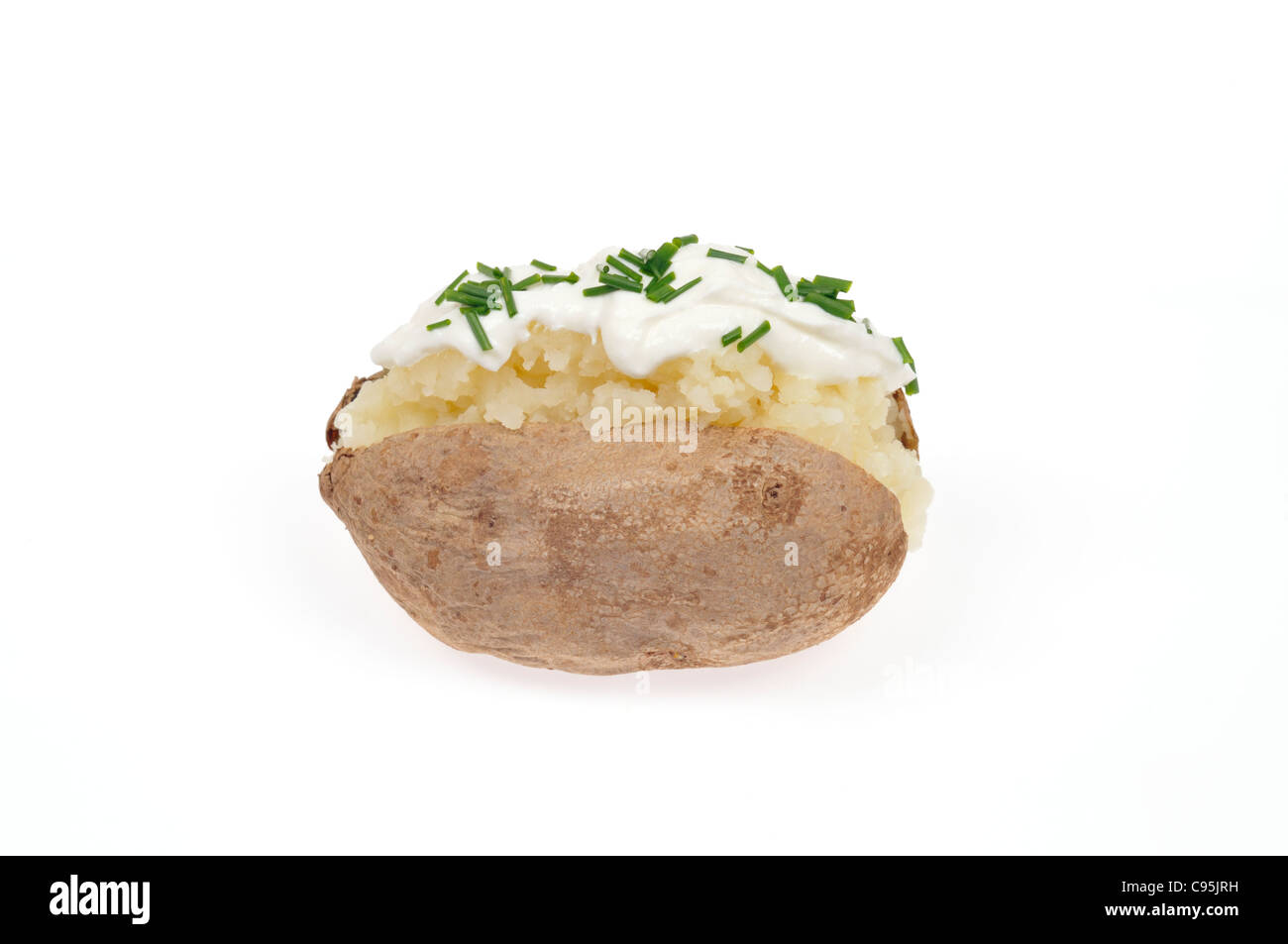Baked potato topped with sour cream and chives on white background cutout. Stock Photo