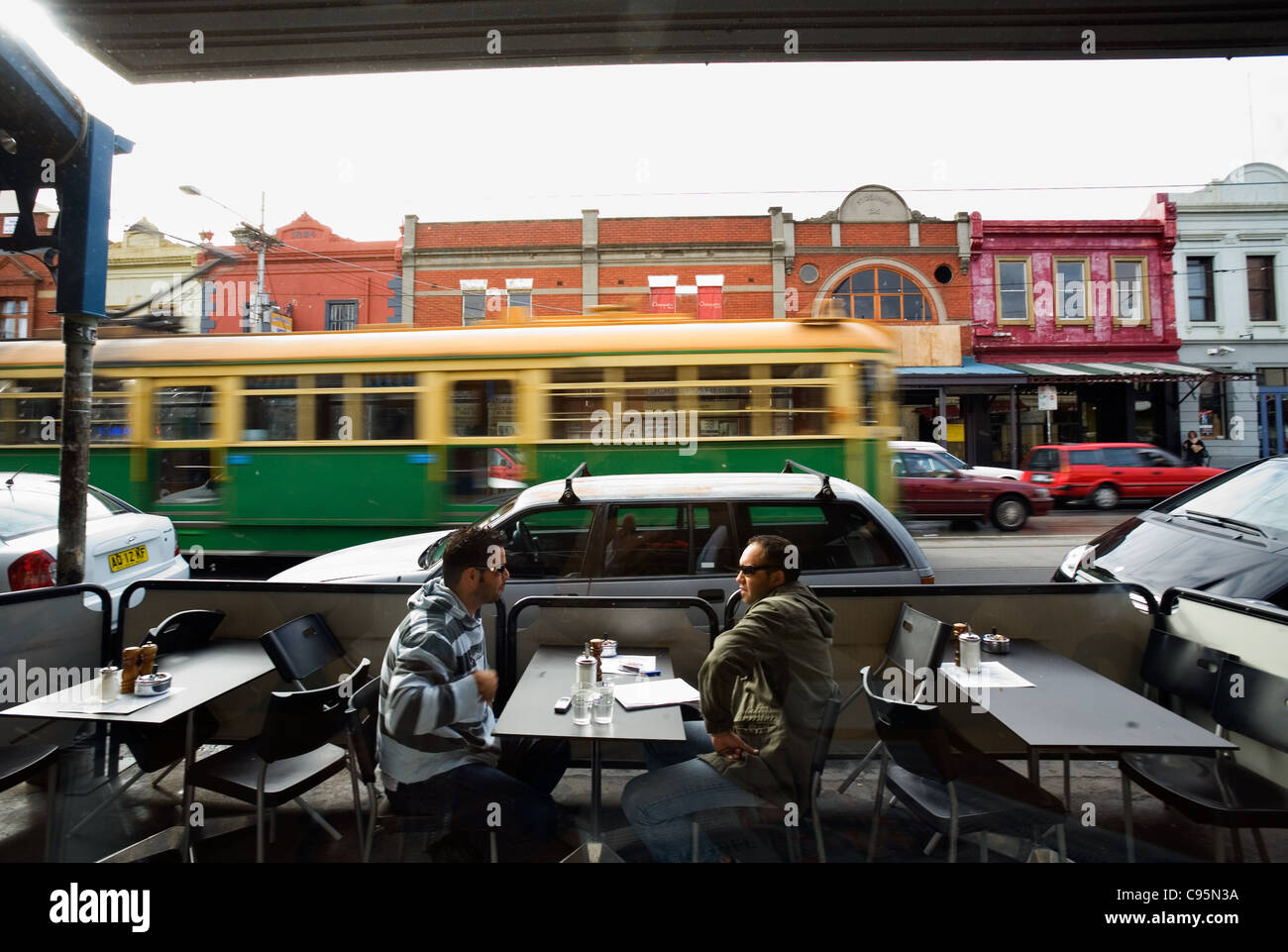 Tram passing a cafe on Brunswick Street in Fitzroy.  Melbourne, Victoria, Australia Stock Photo