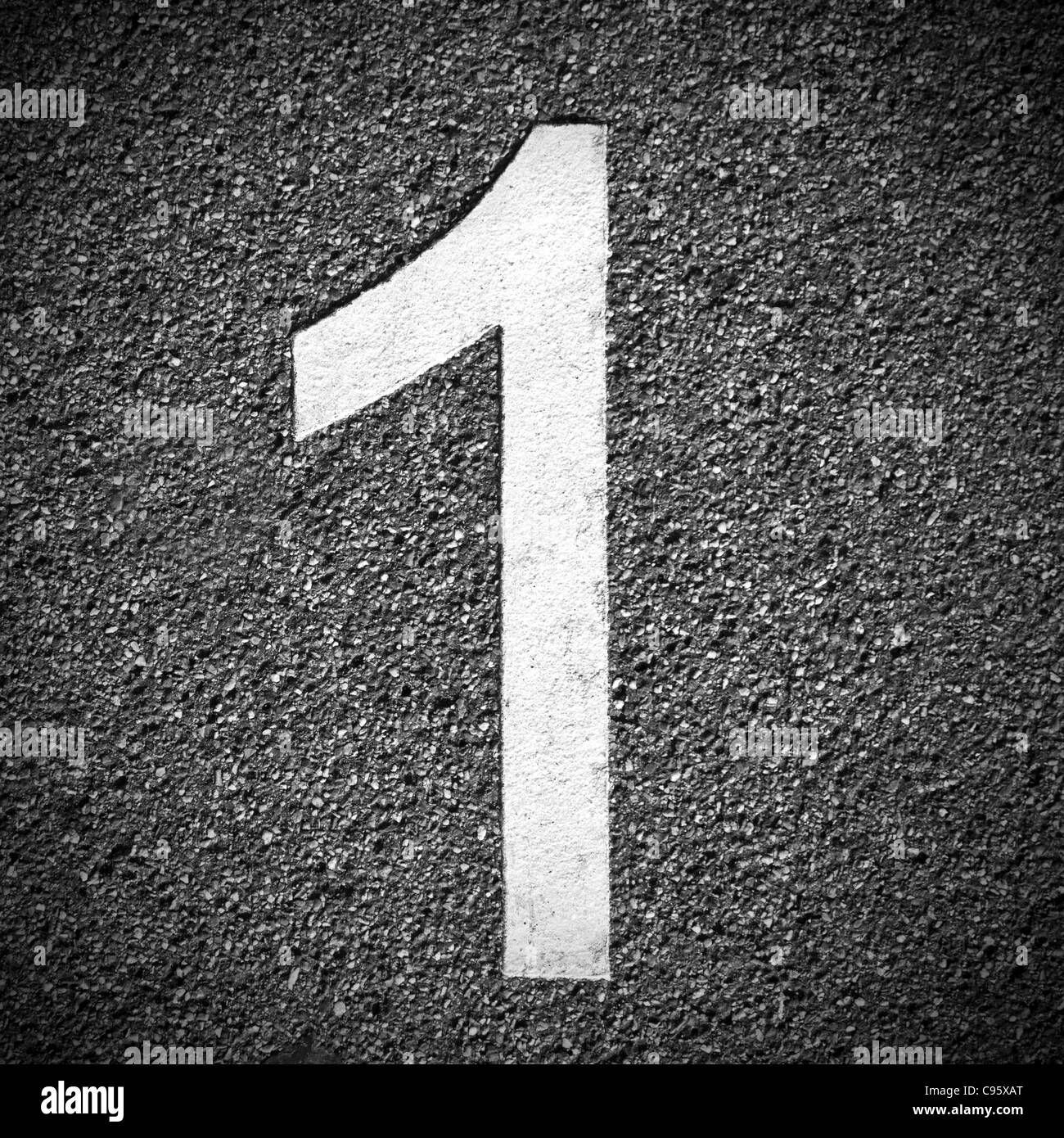 Number one painted in white lettering on grey concrete ground. Background texture. Stock Photo