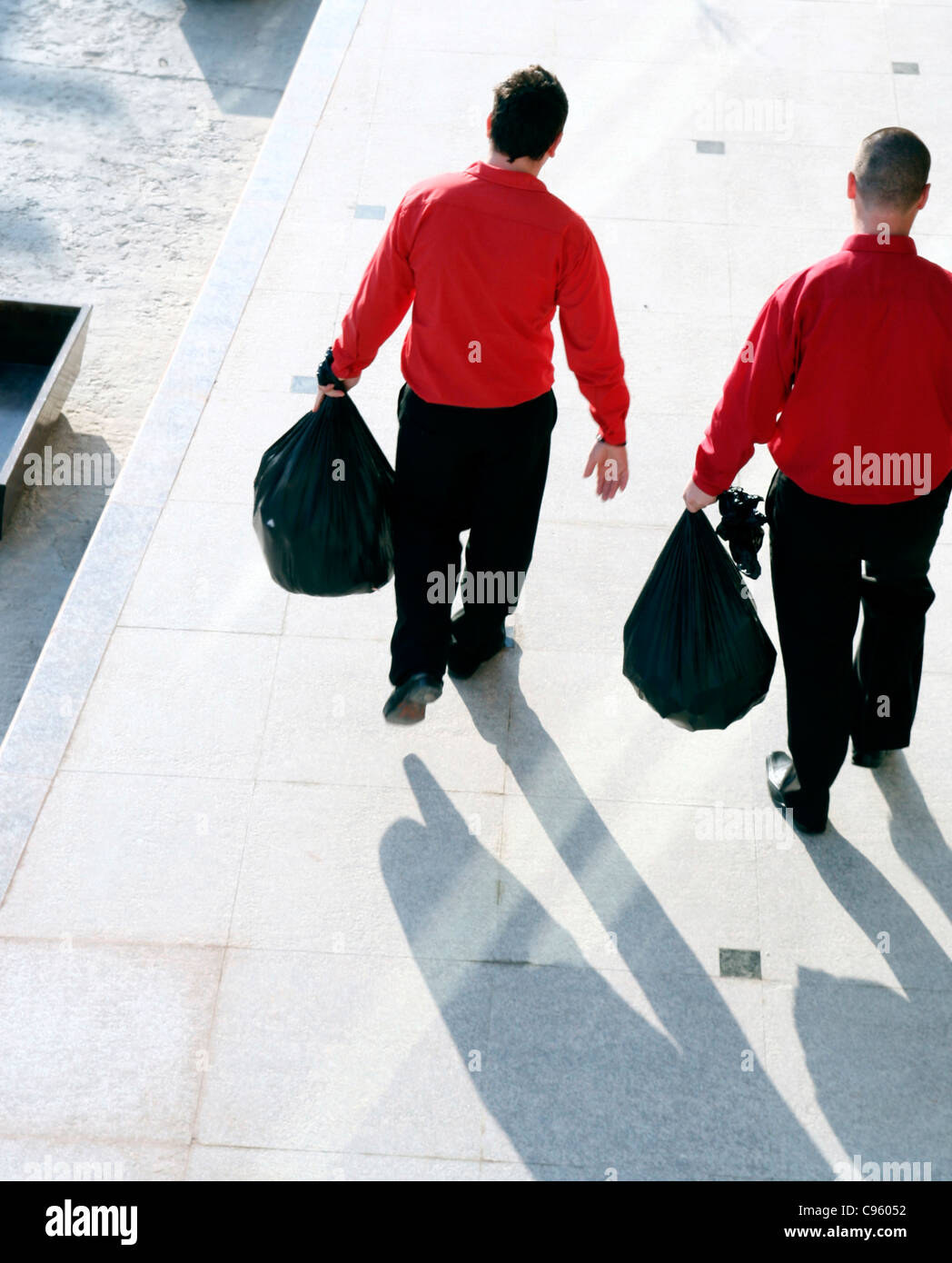 Two men taking out the garbage. Stock Photo