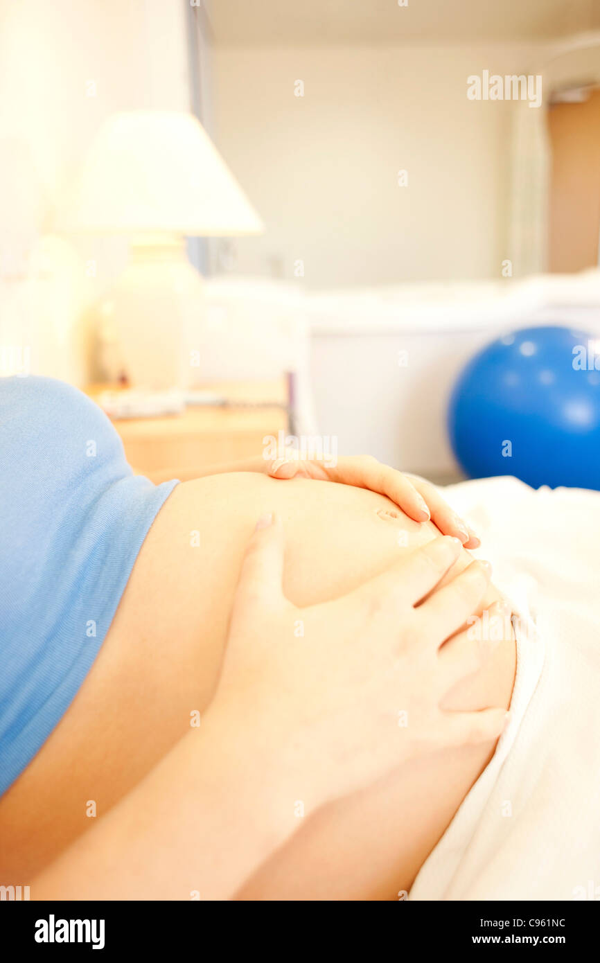 Birthing centre. Close-up of a pregnant woman's abdomen in a room at a birthing centre. Stock Photo