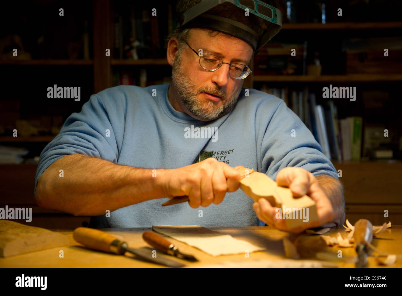 Man carving a bird decoy in his woodworking shop. Stock Photo