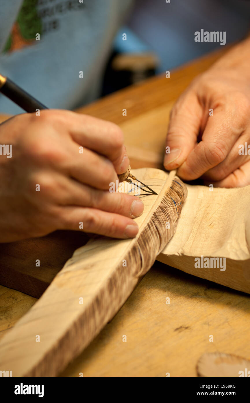 Man carving a bird decoy in his woodworking shop. Stock Photo