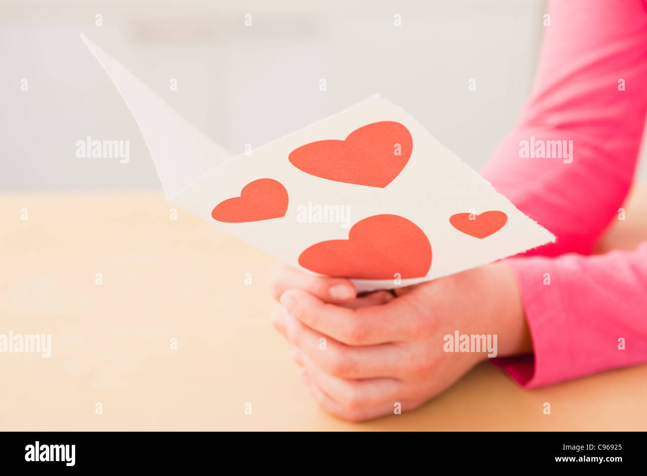 USA, Illinois, Metamora, Girl (10-11) reading greeting card with hearts Stock Photo