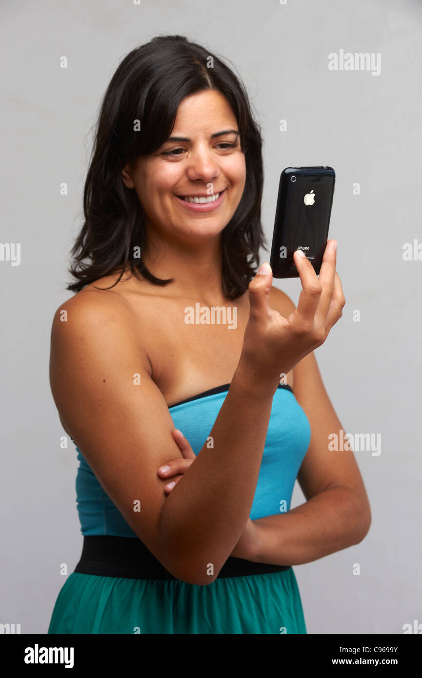 Smiling young woman holding an iPhone Stock Photo