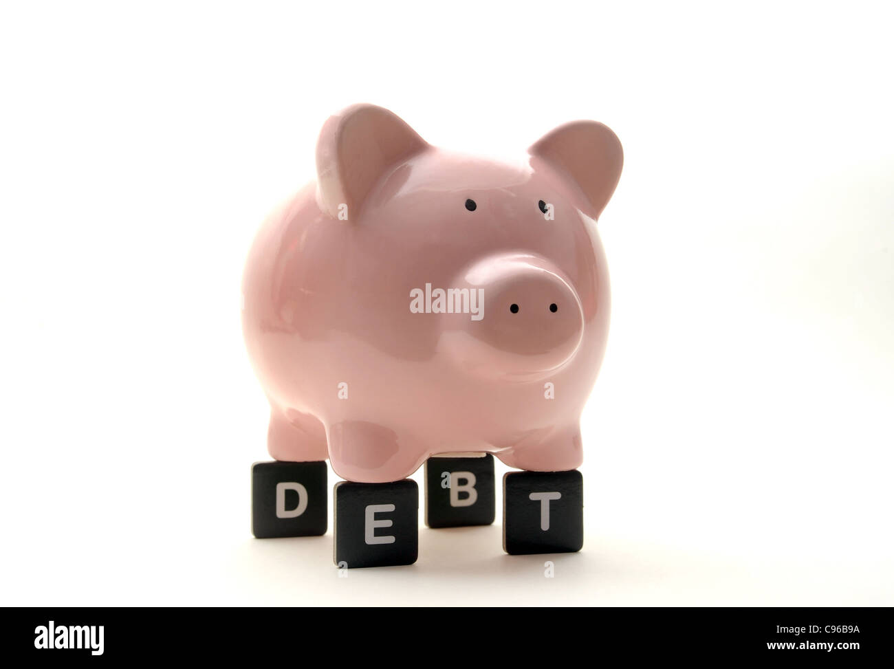 PIGGY BANK ON LETTERS SPELLING 'DEBT' RE FINANCIAL CRISIS SAVINGS ECONOMY ECONOMIC DOWNTURN MONEY  BANKS CASH INCOME WAGES   UK Stock Photo