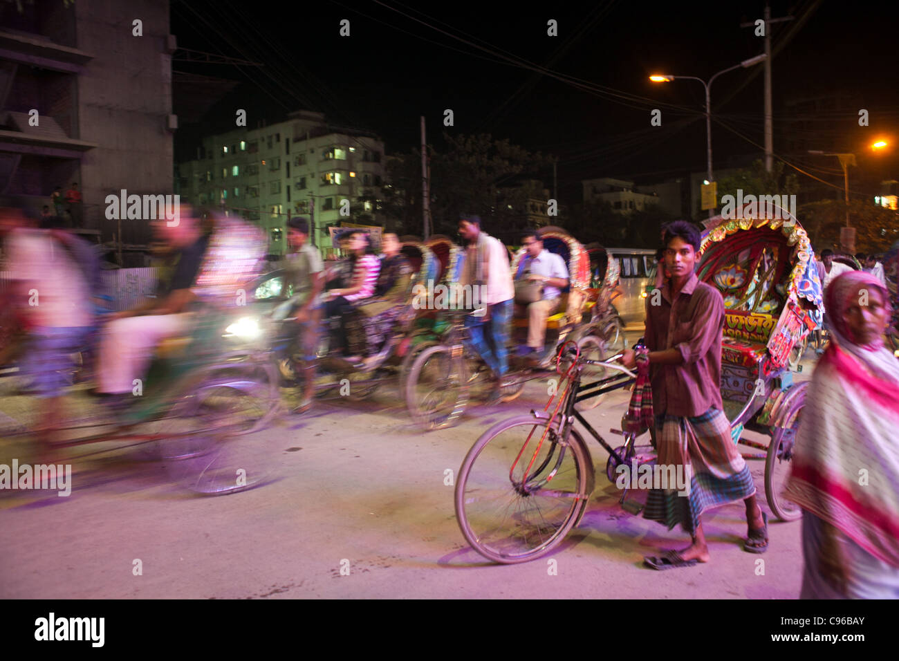 Rickshaws driving people at night in Dhaka. Stock Photo