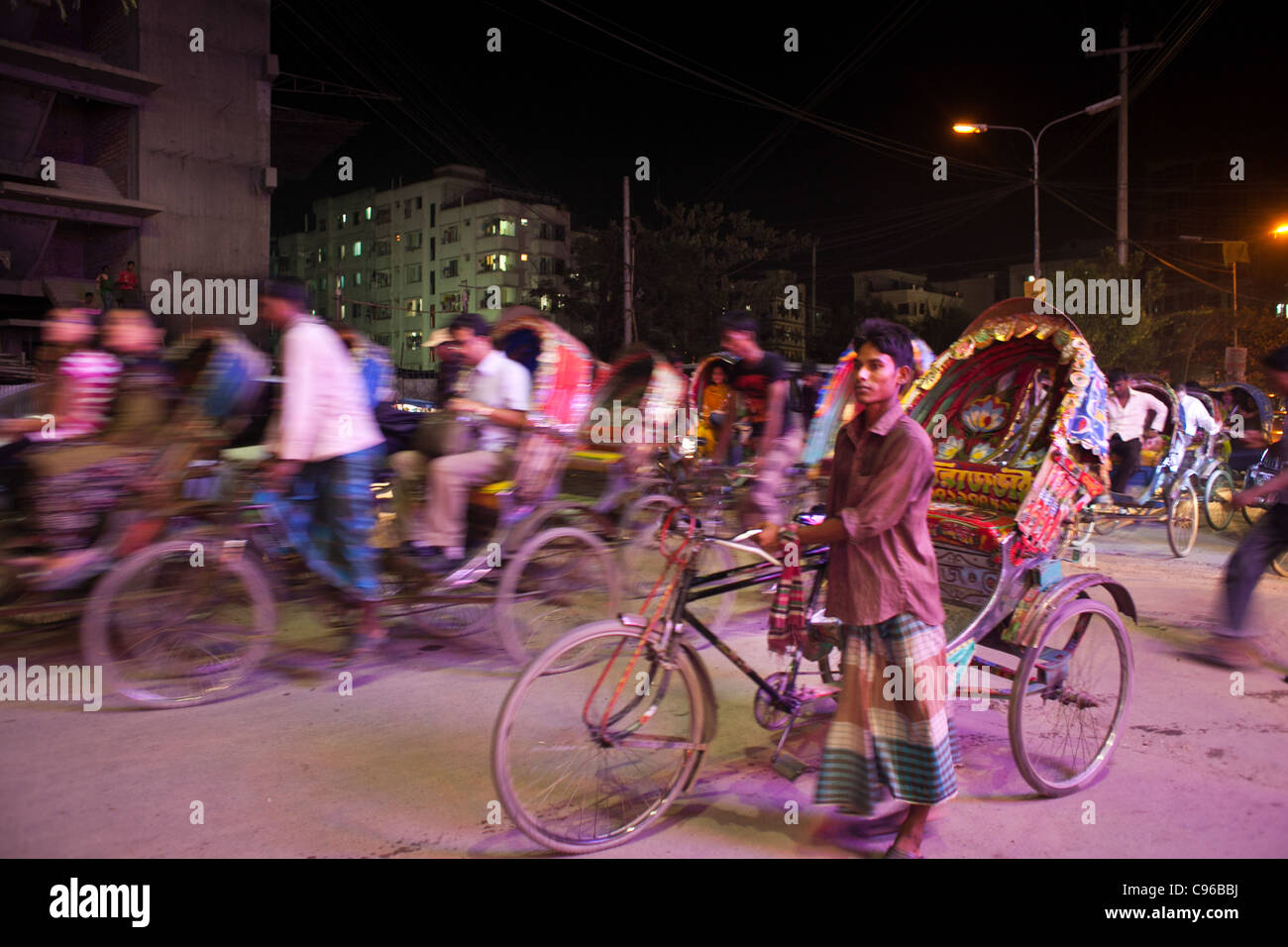Rickshaws driving people at night in Dhaka. Stock Photo