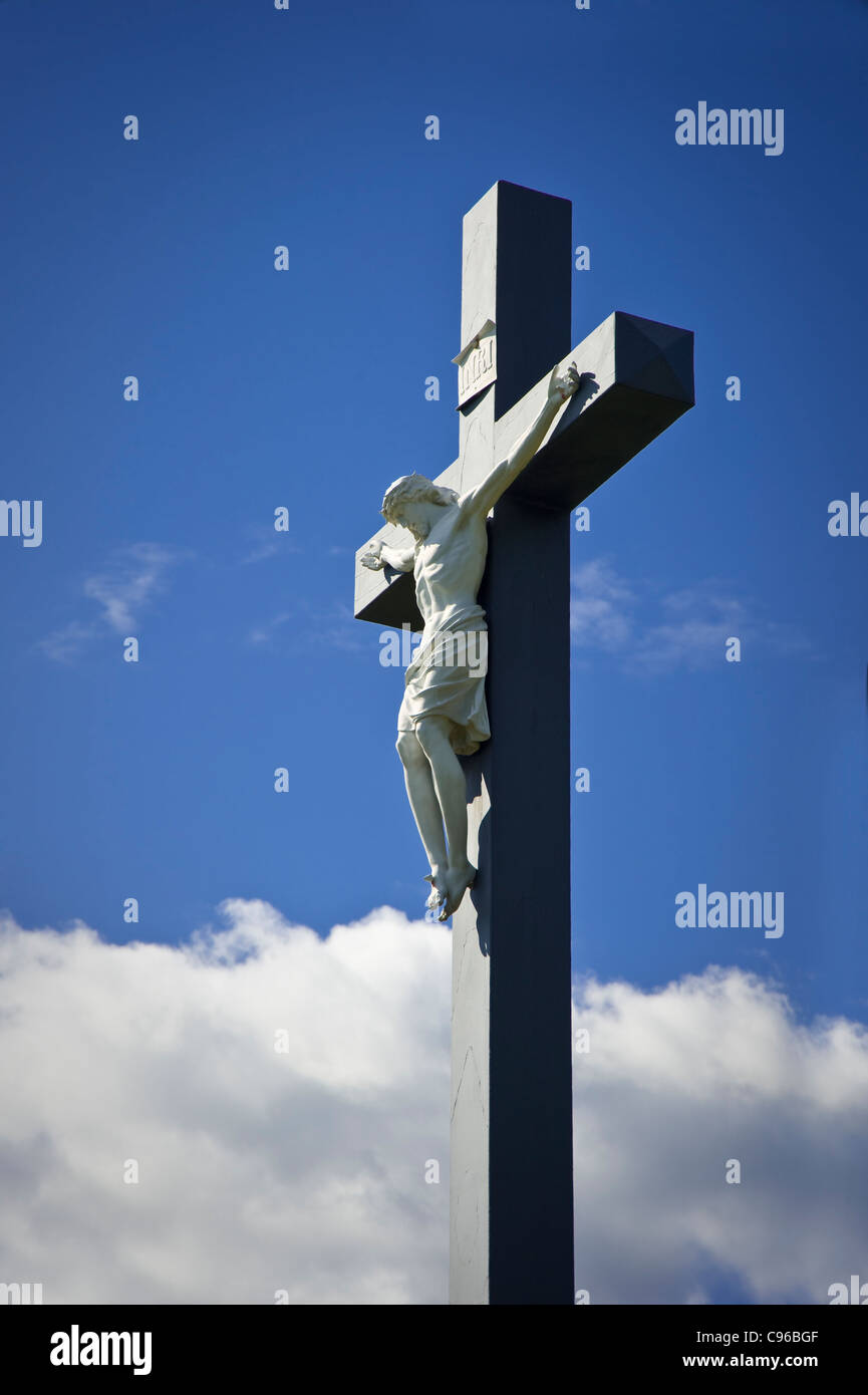 Jesus Christ Hanging On Outdoor Cross With Blue Sky & Clouds Stock Photo