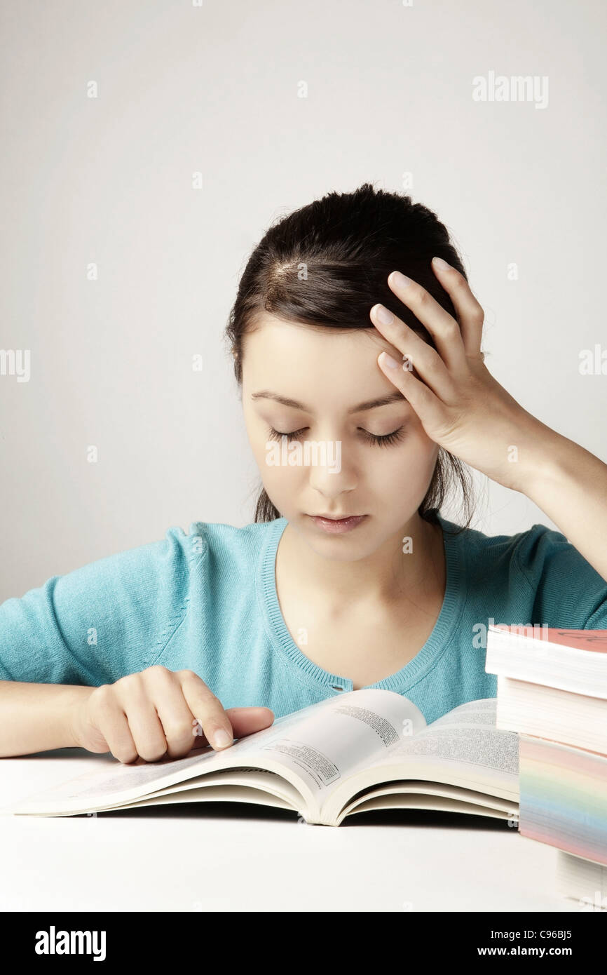 young good looking girl working hard over text books Stock Photo