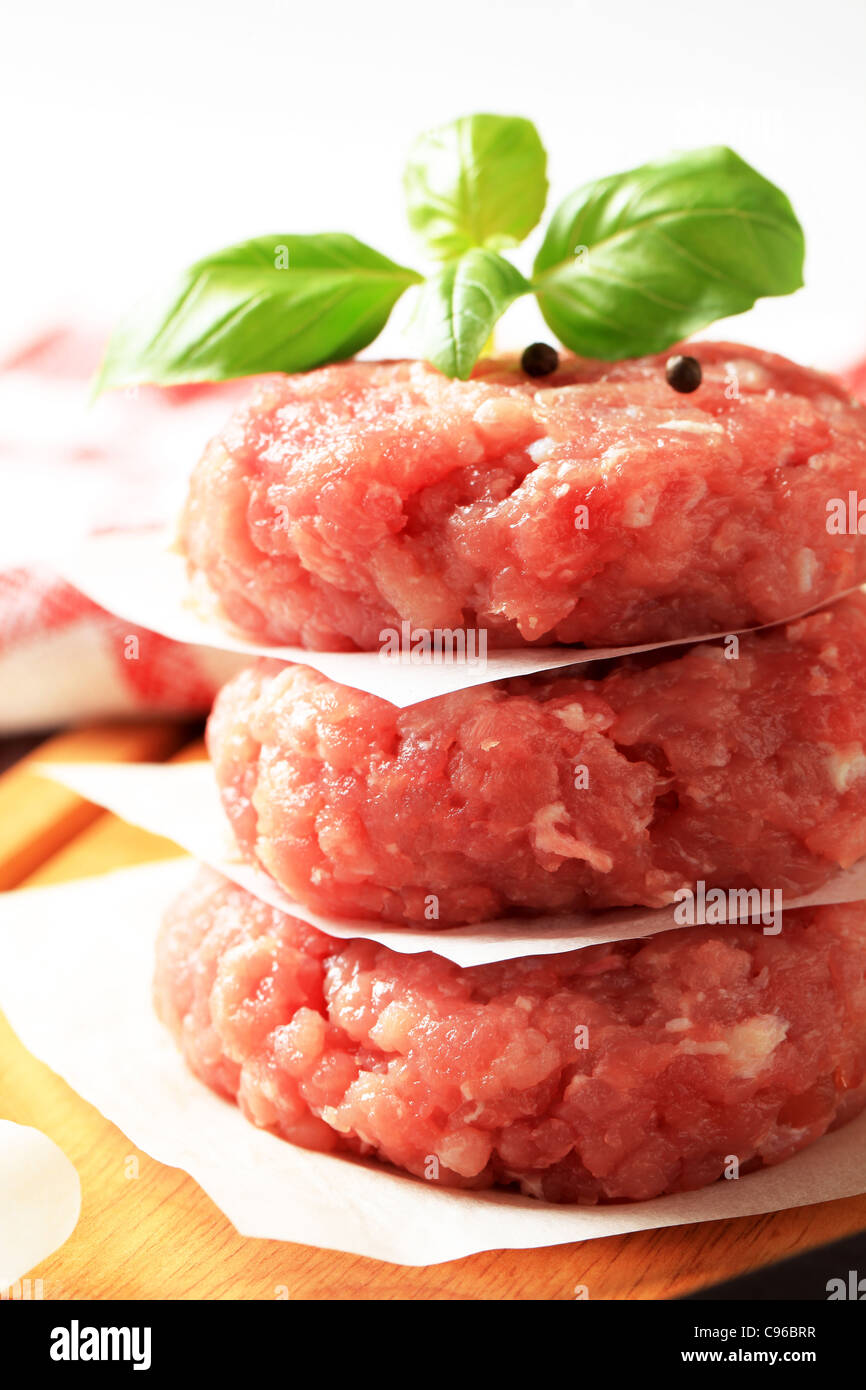 Pile of raw meat patties on a cutting board Stock Photo