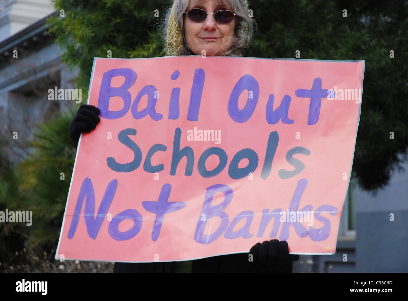 Education supporter carries sign reading 'Bail Out Schools Not Banks' Stock Photo