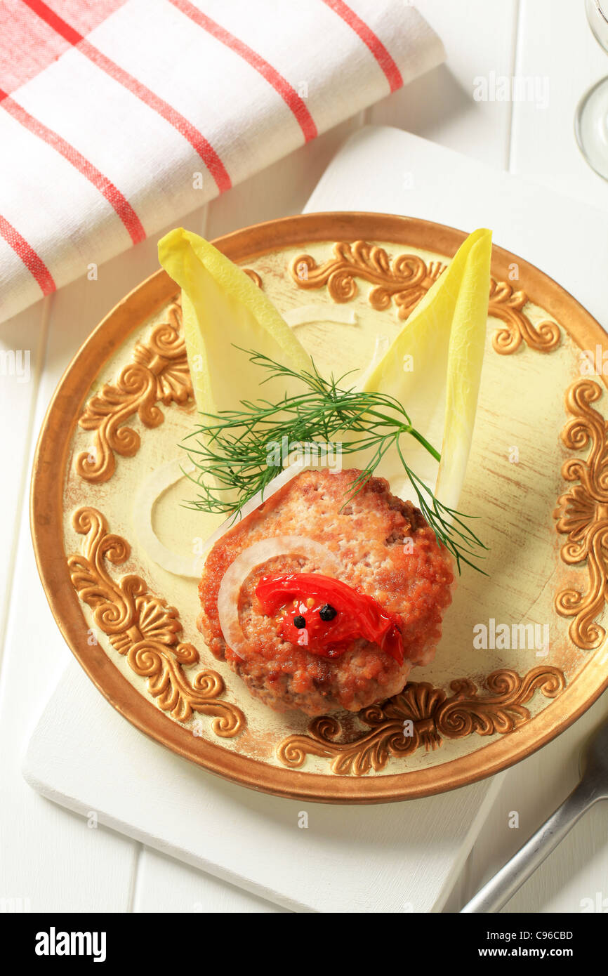 Pan fried burger garnished with endive leaves Stock Photo Alamy