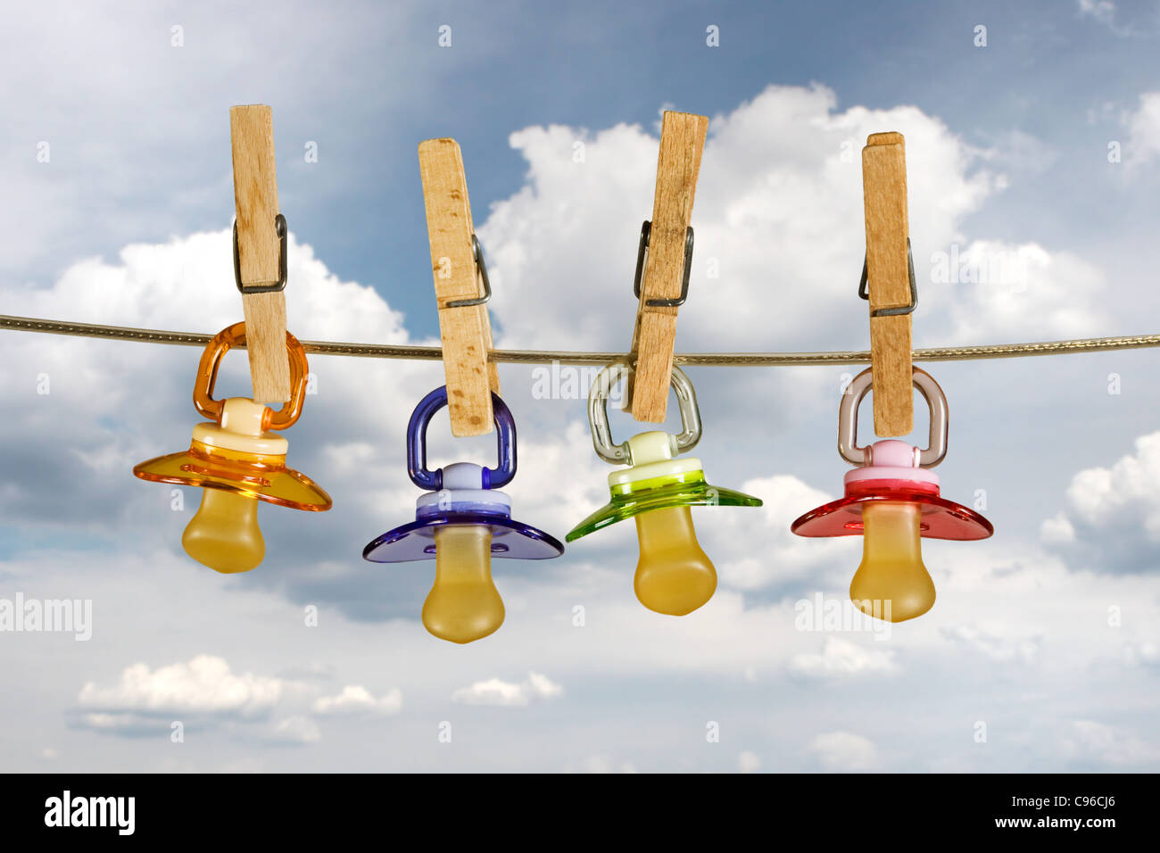 Colored baby pacifiers hanging outside in line Stock Photo