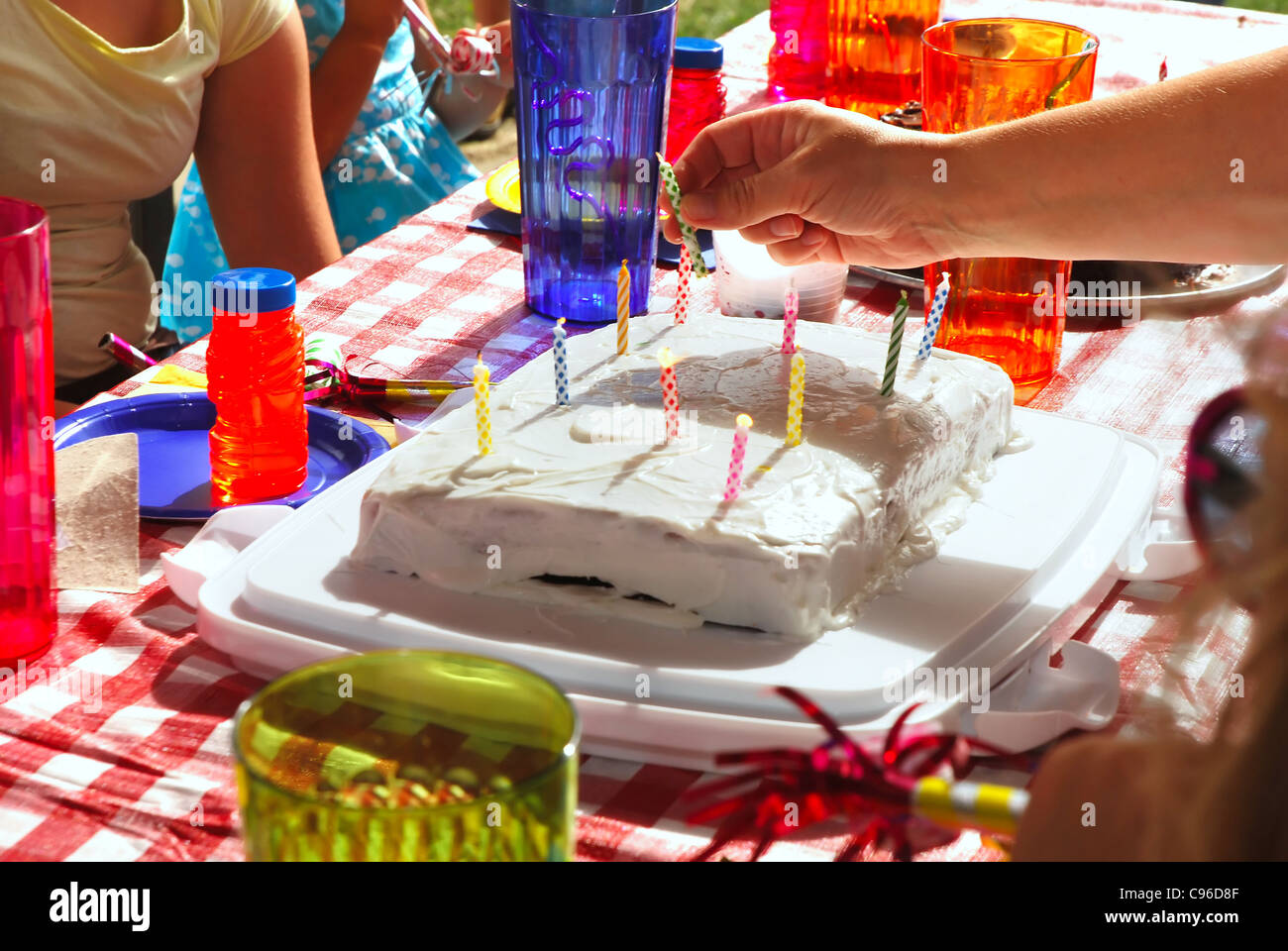 Mom putting candles on a child's birthday cake Stock Photo Alamy