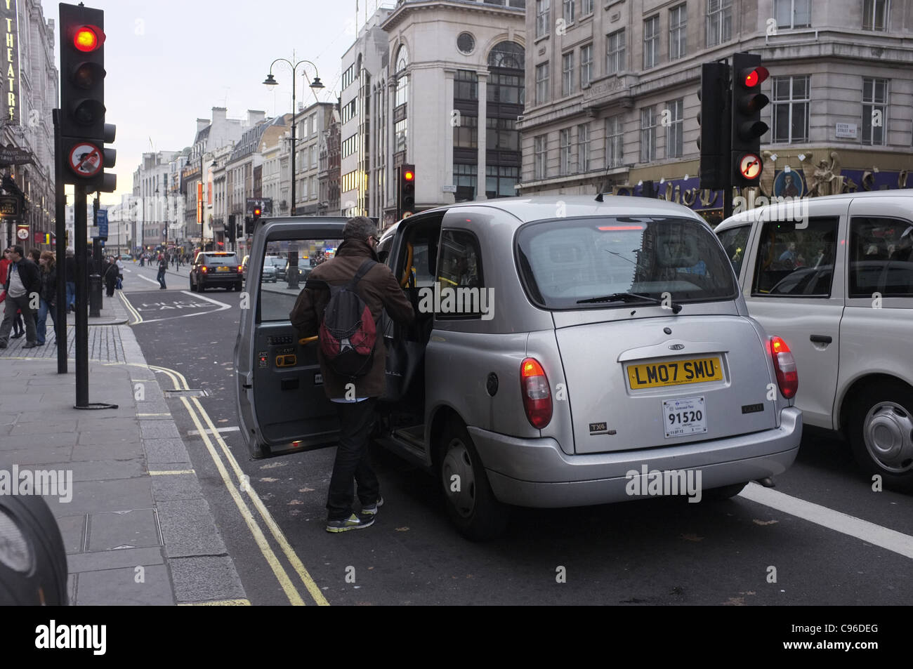 Passenger boarding Taxi at red light in London Stock Photo Alamy