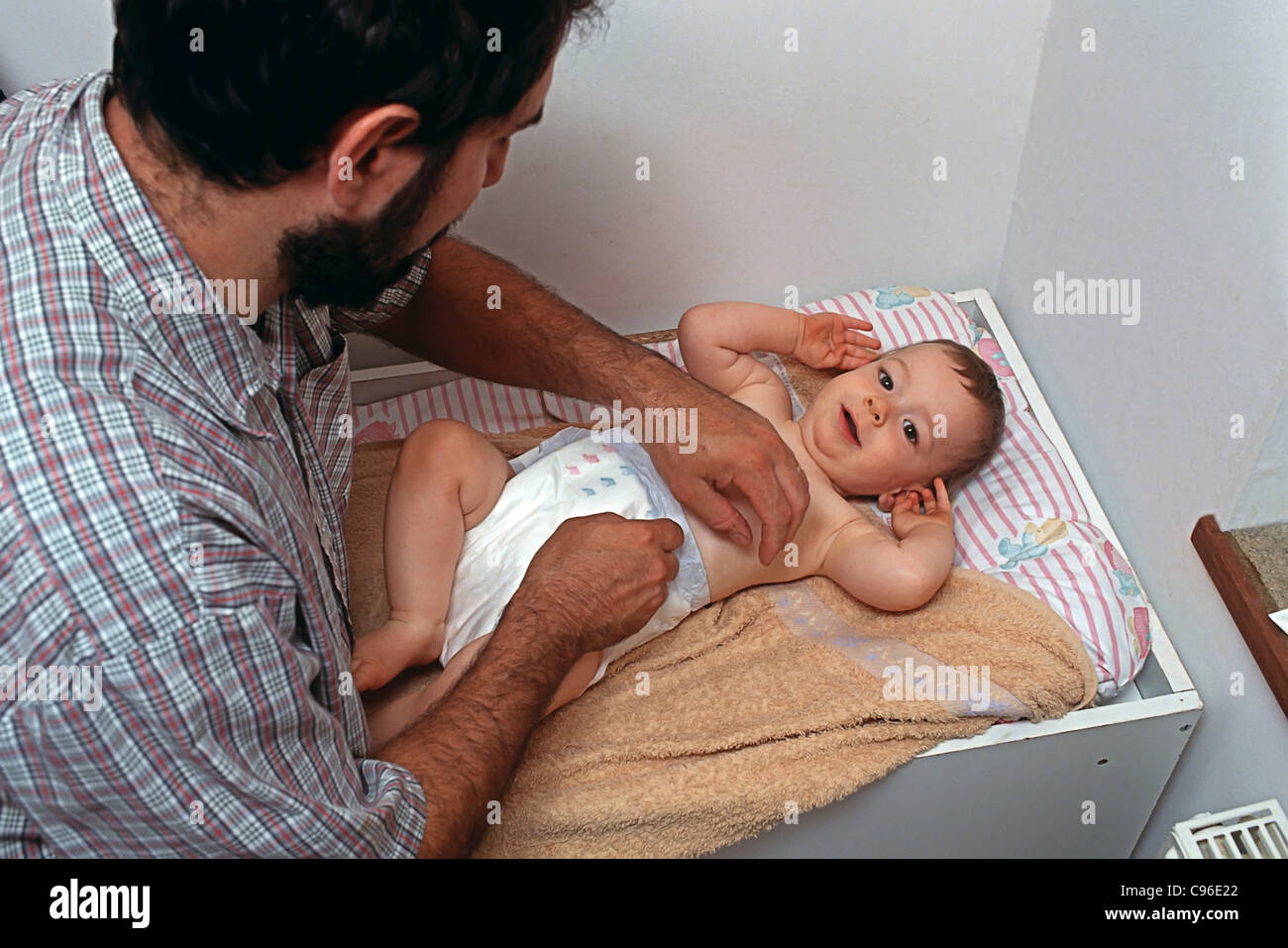 Father changing baby diaper Stock Photo