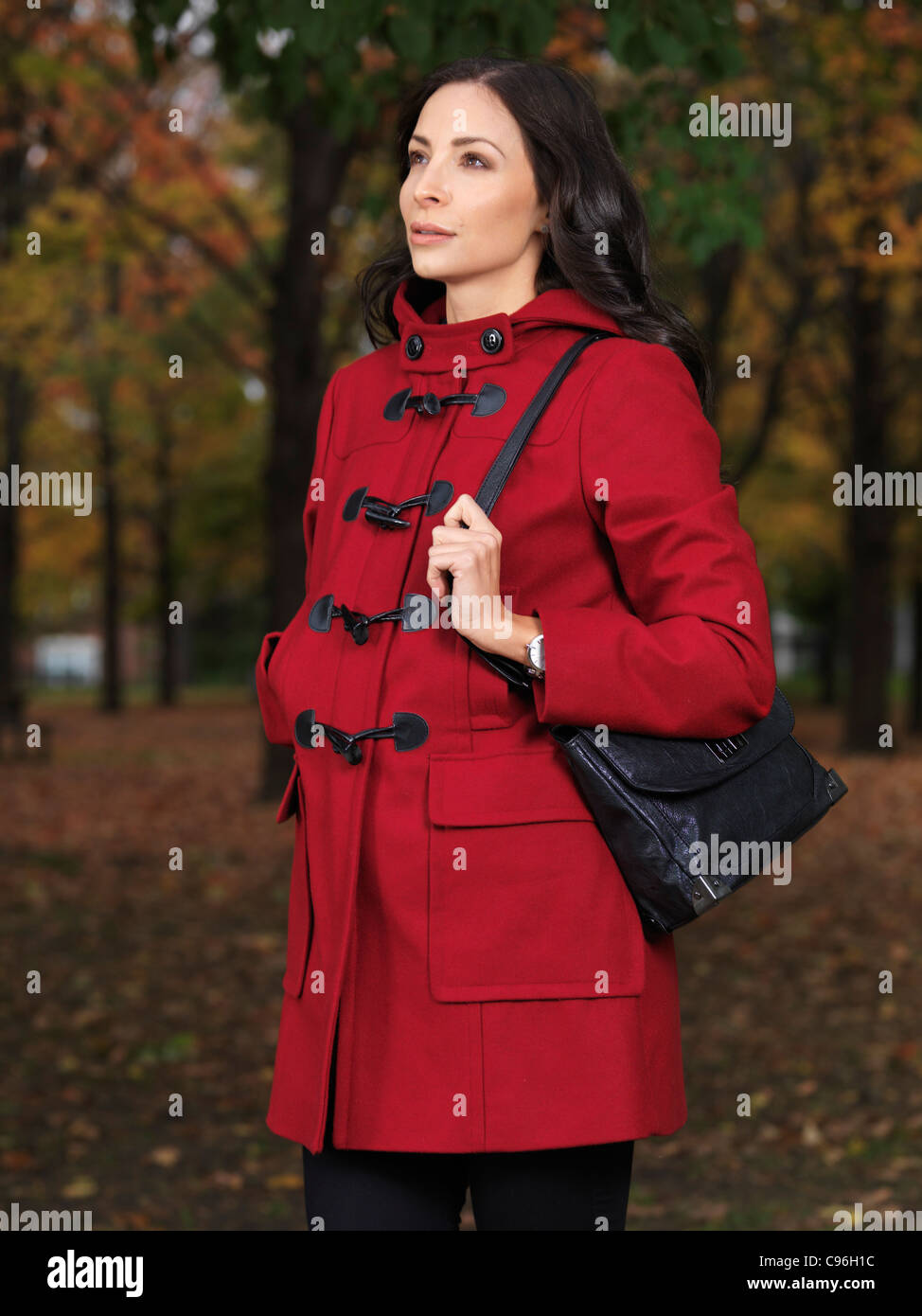 Fall fashion photo of a Beautiful young woman wearing a red coat Stock Photo