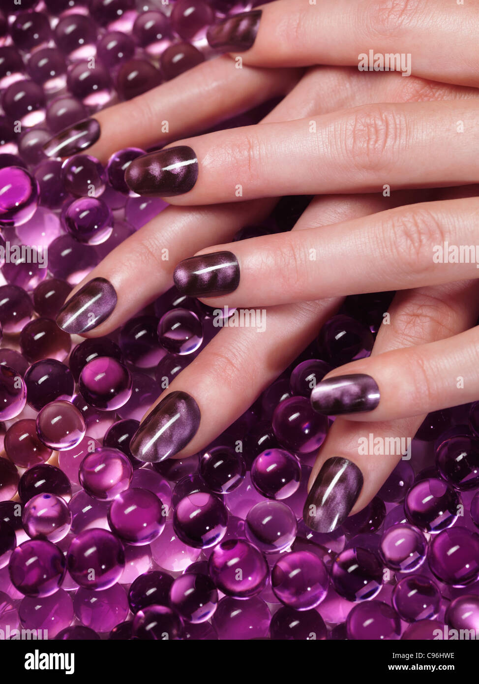 Closeup of woman hand with custom design purple nail polish on abstract  purple background Stock Photo - Alamy