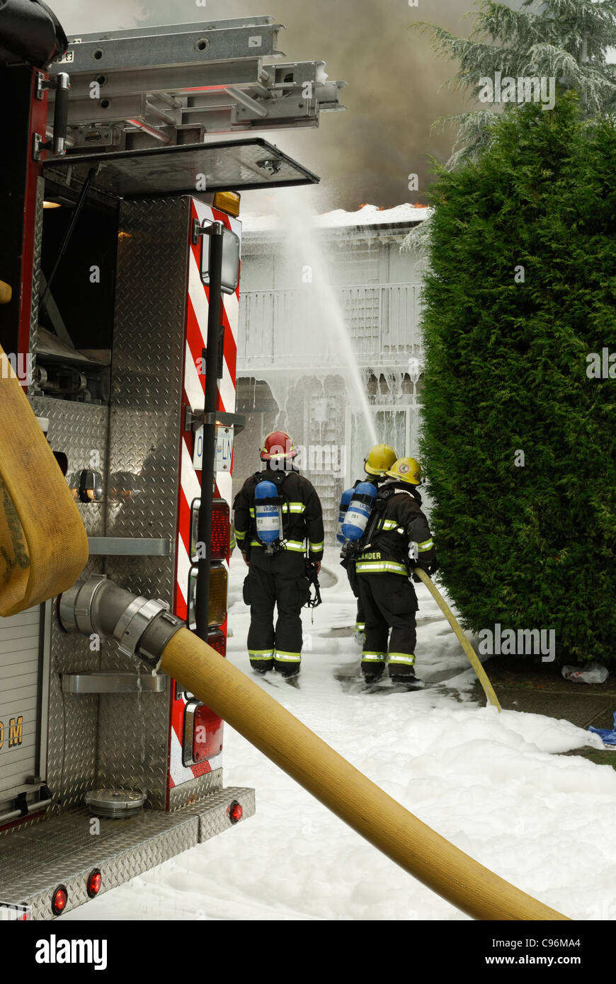 Vancouver firefighters using compressed air foam system to put out a house fire. Stock Photo
