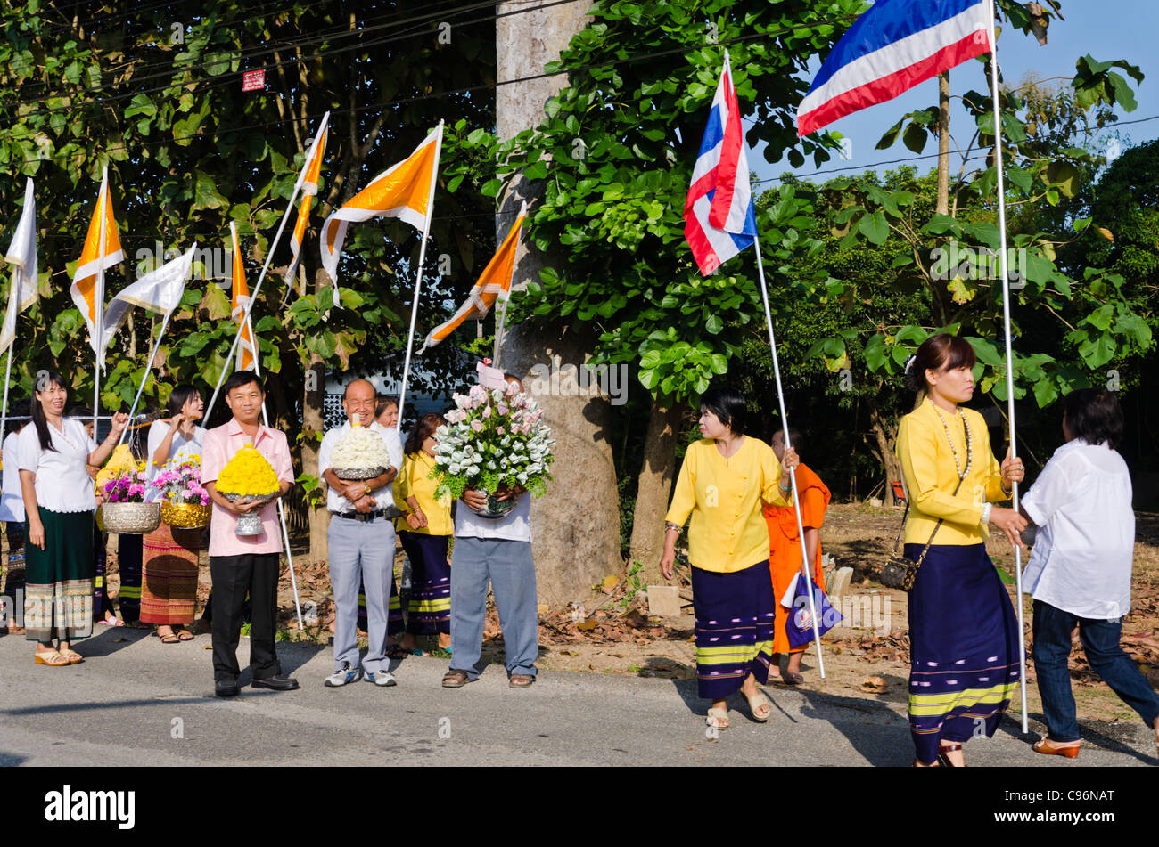 Women wearing traditional clothing carrying Thai flags and banners in ...