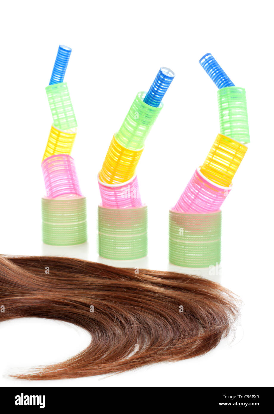 Long female brown hair and multicolored hair curlers at the background. Isolated over white background Stock Photo
