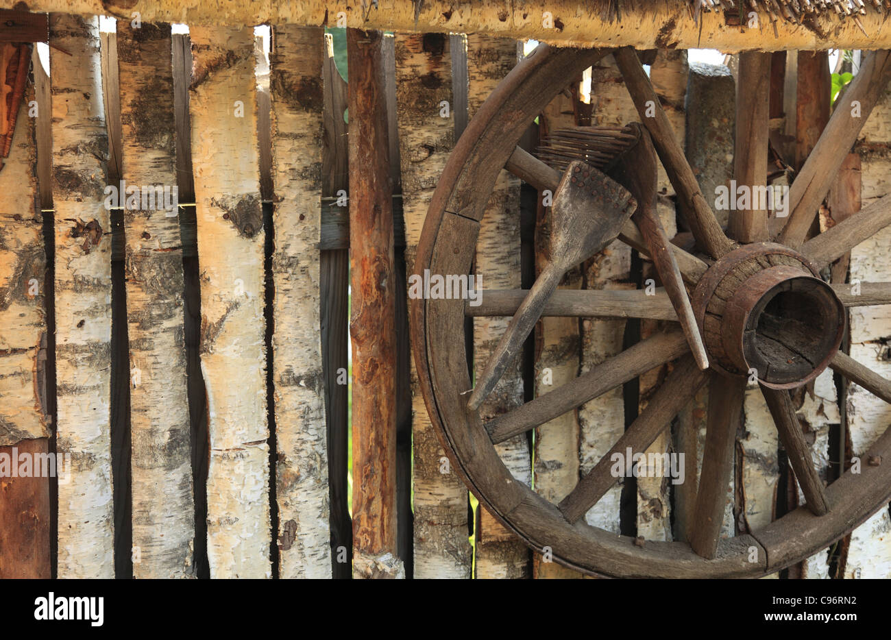 Detail of a rustic wooden fence with an old wagon wheel and traditional ...