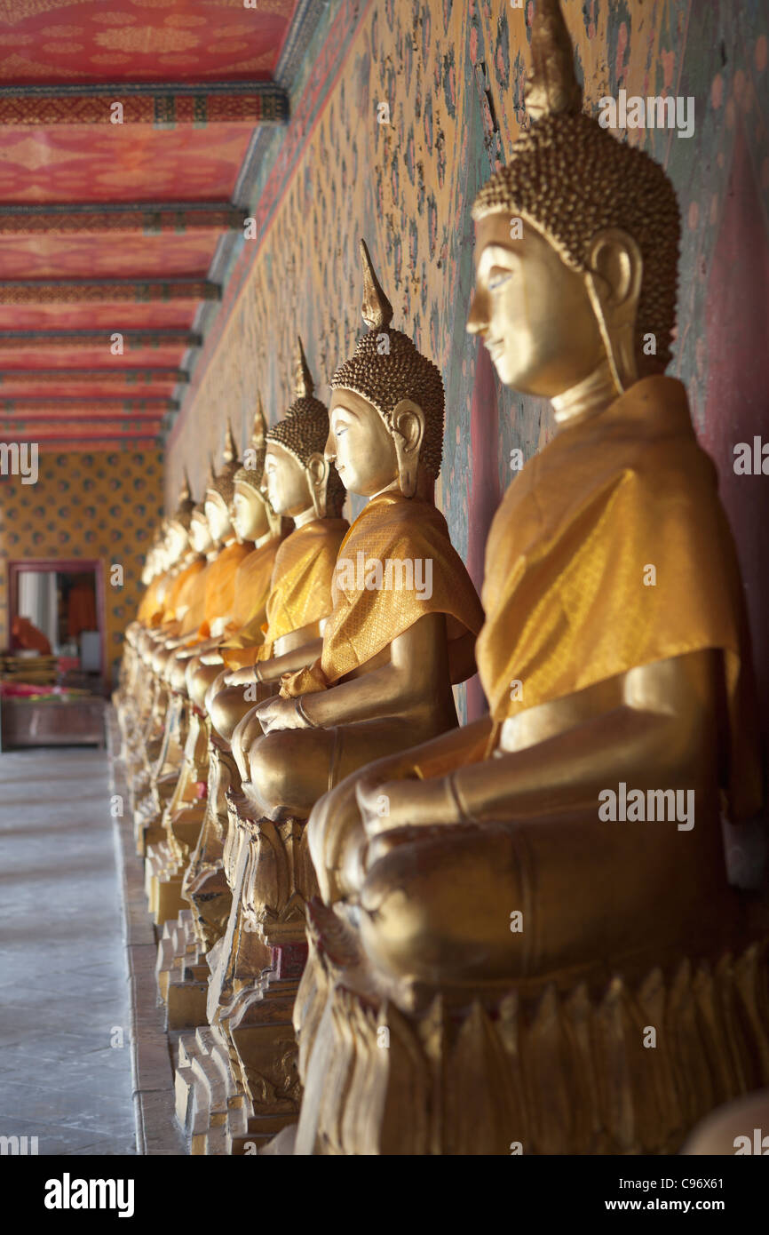 Golden seated Buddha statues in cloister of Wat Arun (Temple of dawn), Bangkok, Thailand Stock Photo