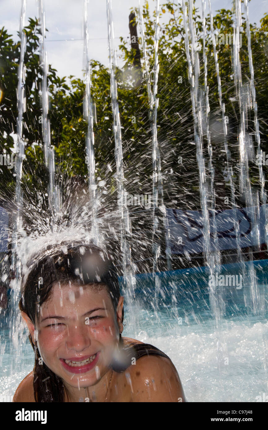 Little young girl playing happy smiling in summer water cascade