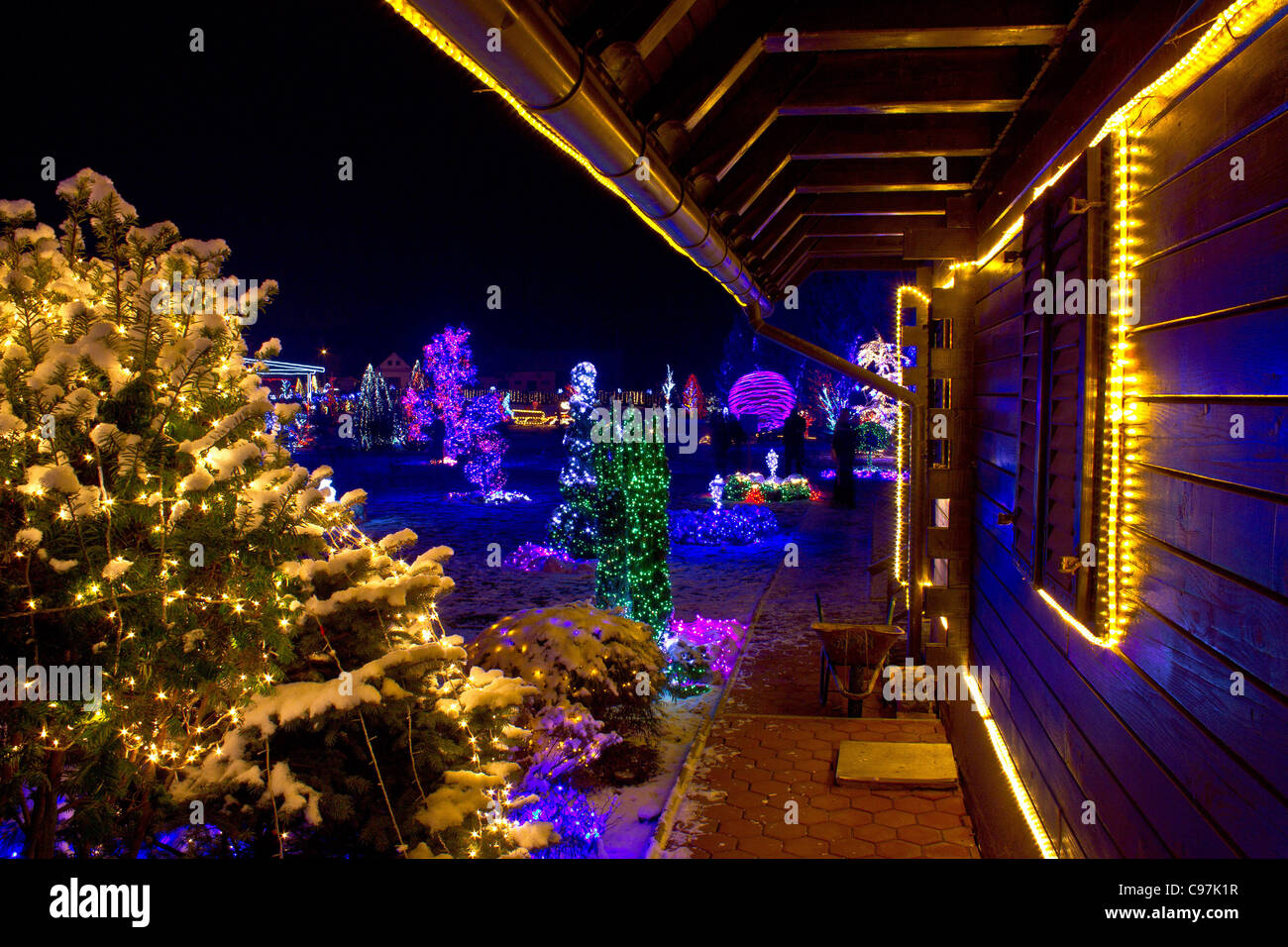 Christmas fantasy - trees and wooden house in lights on a beautiful winter evening Stock Photo