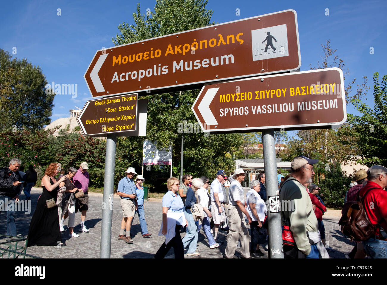Tourists amongst signs on the busy street outside the new Acropolis