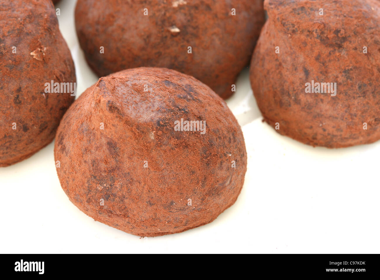 Chocolate truffle pralines sweets covered in cocoa powder on white