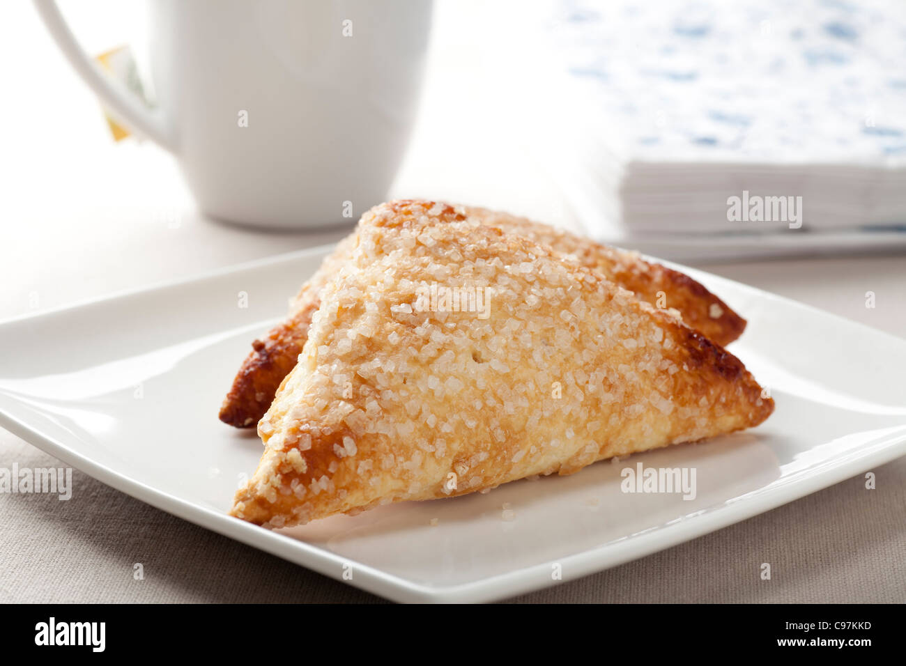 Pastries covered in sugar on white plate. Stock Photo